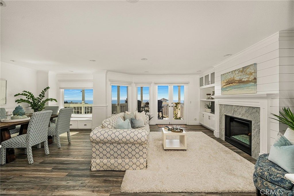Living room with wood-beamed ceiling and glass walls facing the Pacific.